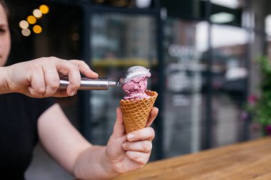 Dondurma külahı. Waffle külahlı dondurma. Waffle külahı bir kız tarafından tutuluyor. Canlı mısır gevreği için renkli malzemeler. Sıcak yaz günleri ya da kış için mükemmel.