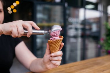Dondurma külahı. Waffle külahlı dondurma. Waffle külahı bir kız tarafından tutuluyor. Canlı mısır gevreği için renkli malzemeler. Sıcak yaz günleri ya da kış için mükemmel.