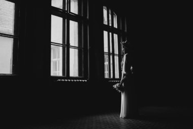 Şapkalı ve buketli gelin. Beyaz elbiseli bir gelinin portresi. Gelinin portresi. Beyaz gelinlik ve bir buket çiçekli şapkalı genç kız..