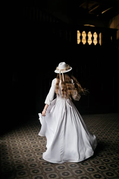 The bride in a hat and a bouquet. Portrait of a bride in a white dress. Portrait of the bride. Young girl in a white wedding dress and hat with a bouquet of flowers.