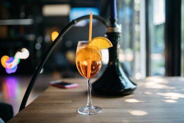Aperol spreyi. Kokteyl. Nargile yakınında Aperol spreyi. Restoranın arka planında nargile var. Nargile dumanı. Masada nefis aperol spreyleri var..