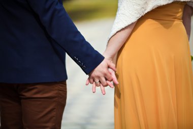 Gelin ve damat el ele tutuşuyorlar.