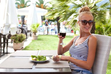 Güzel genç bayan şarap içiyor.