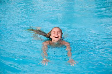 Havuzda yüzen genç bir kadın