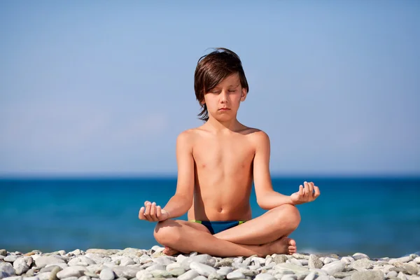 Boy meditating on the beach — Stock Photo, Image