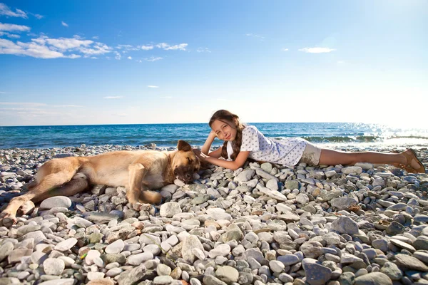 Flicka med hund på stranden — Stockfoto