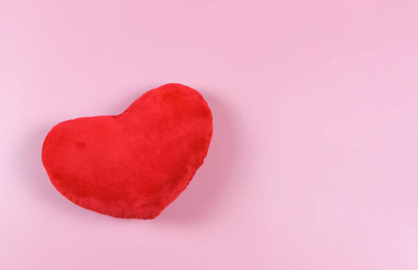 Top view or flat lay of red heart pillow on pink background with copy space, isolated. Valentine's day concept.