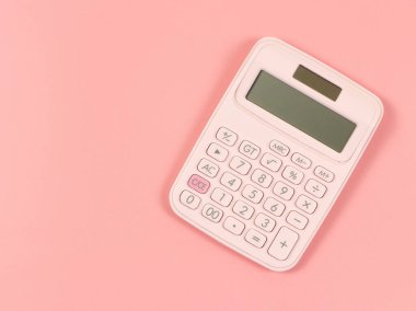 Pembe arkaplanda, kopyalama alanı olan pembe hesap makinesinin üst görünümü veya düz yatağı.