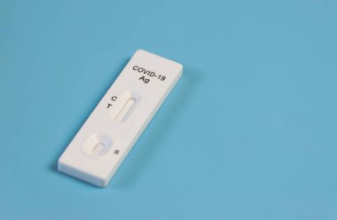 Mavi zemin üzerinde Covid-19 antijen test kitinin üst görünümü.