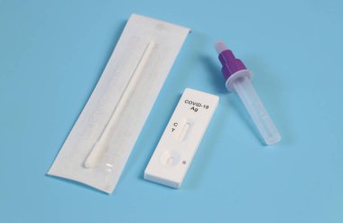 Mavi zemin üzerinde Covid-19 antijen test kitinin üst görünümü.