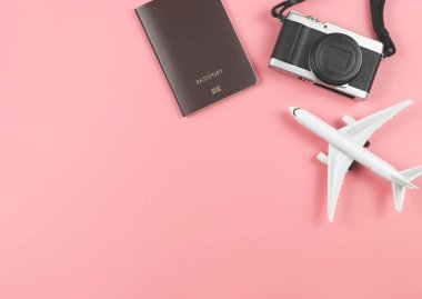 Üst ya da düz pasaport, kamera ve uçak modeli fotokopi alanı ile pembe zemin üzerinde. t