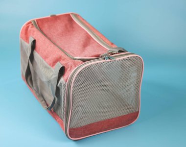 Pet carrier bag  for traveling with pets or visiting veterinarian. Animal transportation bag, isolated on blue background.