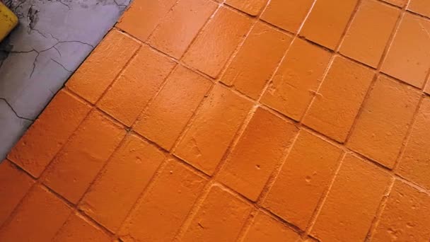 Alte Fliesenwand in leuchtend oranger Farbe bemalt — Stockvideo