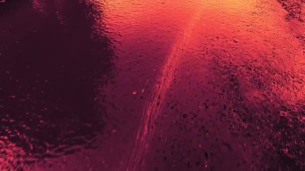 Текстура фона потока воды на асфальте в ярком цвете красного и синего оттенков — стоковое видео