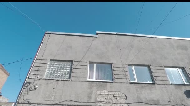 Сіра будівля на фоні блакитного неба — стокове відео
