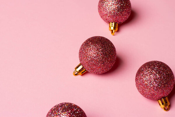 Рождественская и новогодняя композиция с украшениями на розовом фоне.