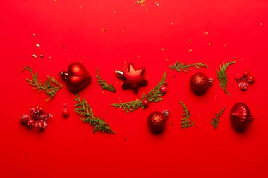 Kırmızı arka planda süslemeleri ve meyve bahçeleri olan Noel kompozisyonu.