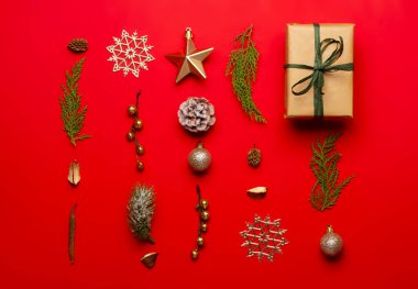 Kırmızı arka planda süslemeleri ve meyve bahçeleri olan Noel kompozisyonu.