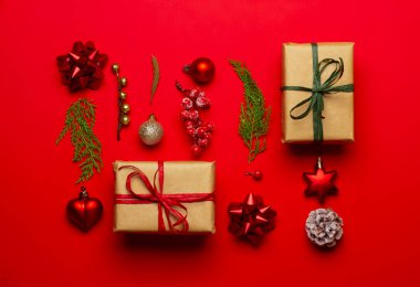 Kırmızı arka planda süslemeleri ve meyve bahçeleri olan Noel kompozisyonu.