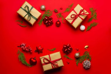 Kırmızı arka planda süslemeleri ve meyve bahçeleri olan Noel kompozisyonu.