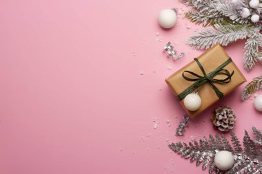 Noel kompozisyonu pembe arka planda süslemeler ve meyve bahçeleri.