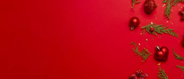 Kırmızı arka planda süslemeleri ve meyve bahçeleri olan Noel kompozisyonu.