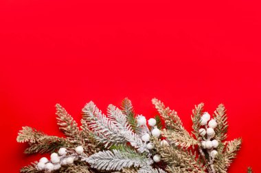 Kırmızı arka planda süslemeleri ve meyve bahçeleri olan Noel kompozisyonu.