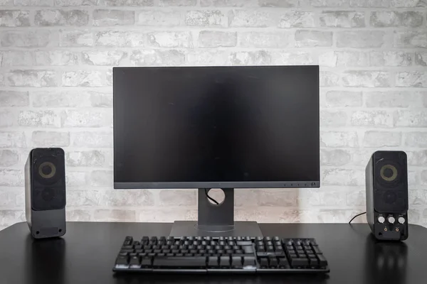 Computer workspace with black screen monitor and copy space for text or designs. Gamer Rig.