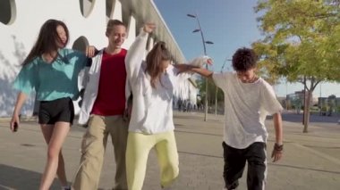 Çok ırklı, mutlu genç arkadaşlar sokakta birbirlerine sevgiyle sarılıyorlar..