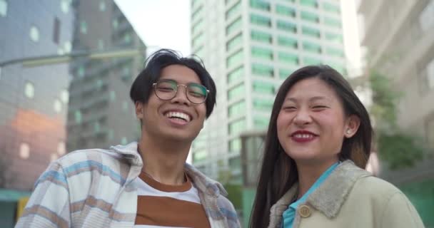 Porträtt av ett vackert asiatiskt par som ler mot kameran under solnedgången. — Stockvideo