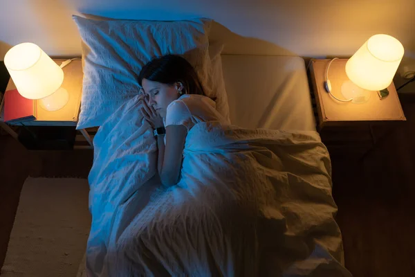 Vista dall'alto di una bella ragazza che dorme comodamente su un letto nella sua camera da letto con Blue Colors from the moon. — Foto Stock
