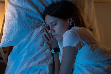 Ay 'dan gelen mavi renklerle, gece yatağında rahat bir şekilde uyuyan güzel bir kızın en güzel görüntüsü..