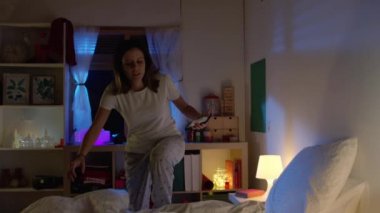 Güzel genç bir kız gece yatağında uyuyor. 4K ağır çekim kırmızı kamera sinematografik video.