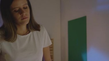 Güzel genç bir kız gece yarısı odasında orta pozuyla yatağa giriyor. 4K ağır çekim kırmızı kamera sinematografik video.