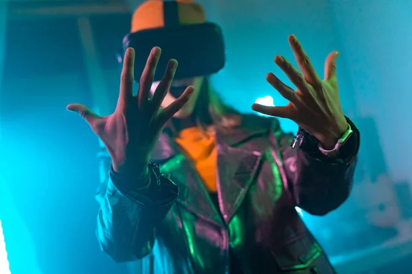 Trådlös teknik. ung kvinna med hjälp av virtuella verklighets glasögon i det mörka rummet med neon belysning. — Stockfoto