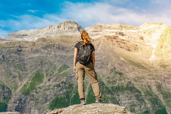 Jonge vrouw met een rugzak op de top van een rots in een prachtig wild landschap. Ontdekking Reisbestemming Concept — Stockfoto