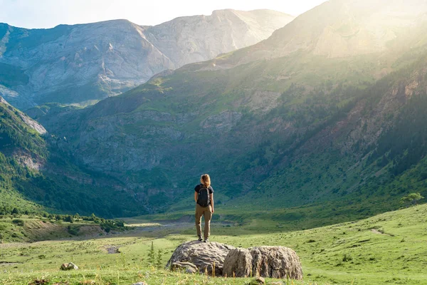 Egy fiatal nő hátizsákkal egy szikla tetején egy gyönyörű vadonban. Discovery Travel Destination koncepció — Stock Fotó