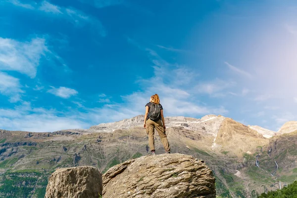 Jonge vrouw met een rugzak op de top van een rots in een prachtig wild landschap. Ontdekking Reisbestemming Concept — Stockfoto