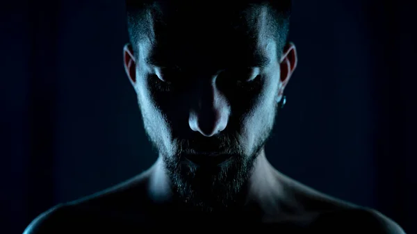 Retrato de atraente modelo masculino jovem em luz de fundo cinematográfica sobre fundo preto sem camisa. Ficção científica. — Fotografia de Stock