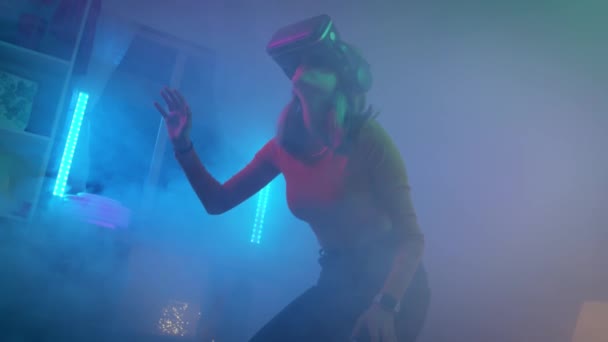 Junge Frau mit Virtual-Reality-Brille im dunklen Raum mit neonbeleuchteter 4K-Zeitlupenkamera. Drahtlose Technologien. — Stockvideo