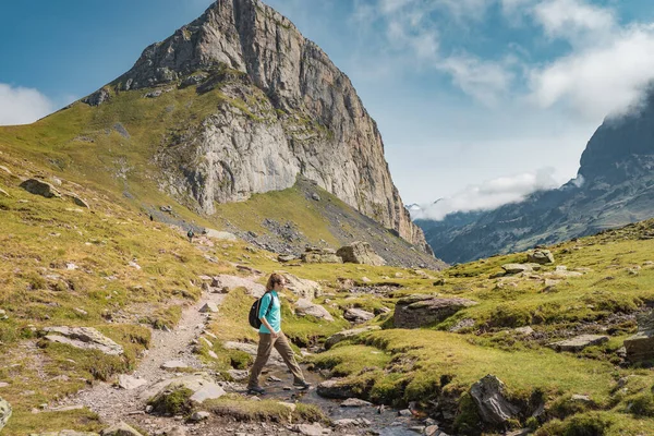 Young Attractive Woman With A Backpack hiking in a beautiful valley between mountains during the sunset. Discovery Travel Destination Concept — Stock Fotó