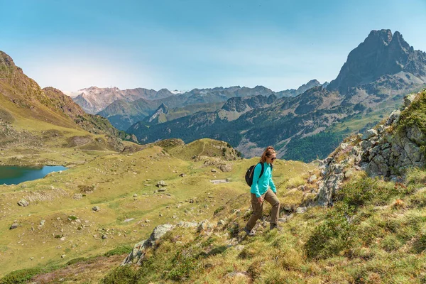 Young Attractive Woman With A Backpack hiking in a beautiful valley between mountains during the sunset. Discovery Travel Destination Concept — Stock Fotó