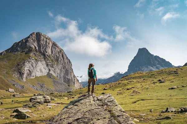 Egy fiatal nő hátizsákkal egy szikla tetején egy gyönyörű vadonban. Discovery Travel Destination koncepció — Stock Fotó