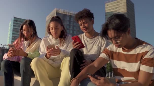 Een Groep Gelukkige Tienervrienden Zoek Naar Hun Telefoon Een Bankje — Stockvideo