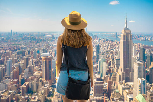 Travel tourist woman enjoying view of Manhattan skyline in New York city. Happy lifestyle girl with hat. High quality photo