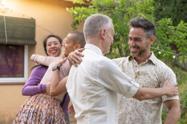 Çok ırklı orta yaşlı erkekler ve kadınlar birbirlerini selamlar ve mutlu bir şekilde bir araya gelirler. Yüksek kalite fotoğraf