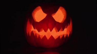 Cadılar Bayramı balkabağı suratlı, siyah arka planda mum ışığı olan. Turuncu korkunç Jack O Lantern 4K. Yüksek kalite 4k görüntü