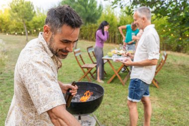 Barbeküdeki insanlar mutlu bir şekilde gülümsüyor ve birlikte gülüyorlar. Eğlence konsepti. Yüksek kalite fotoğraf