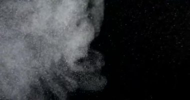 Toz parçacıkları ağır çekimde siyah ekranda patlıyor. Atmosfer kaplaması. RED kamerayla çekildi. Yüksek kalite 4k görüntü
