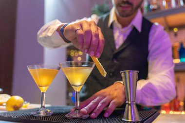 Yakışıklı barmen, gece kulübü partisinde ışıkları olan gece kulübünde şık bir kokteyl hazırlıyor. Yüksek kalite fotoğraf